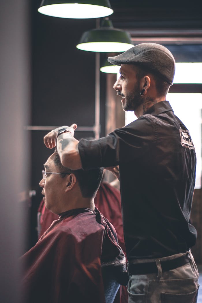 Barber skillfully trims customers hair in a modern salon, capturing hairstyle expertise.